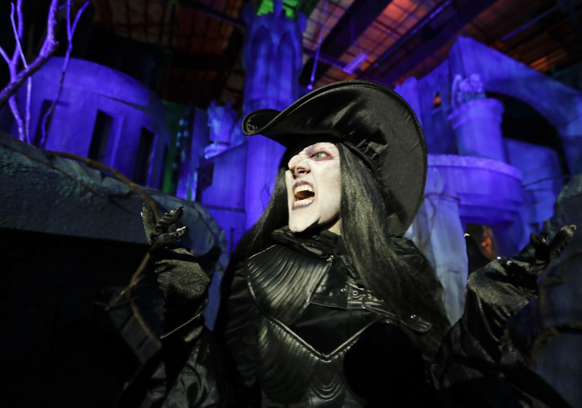 FILE - In this Sept. 12, 2018 file photo, Laura Law performs as a witch at the Scary Tales haunted house at Halloween Horror nights at Universal Studios in Orlando, Fla. After a pandemic-related absence of almost two years, Universal Orlando Resort's celebration of all things scary opened for screams on Friday, Sept. 3, 2021. Halloween Horror Nights kicked off at the Florida theme park resort for a 30th year of disturbing haunted houses, live entertainment and celebrations of pop-culture scares. (AP Photo/John Raoux, File)