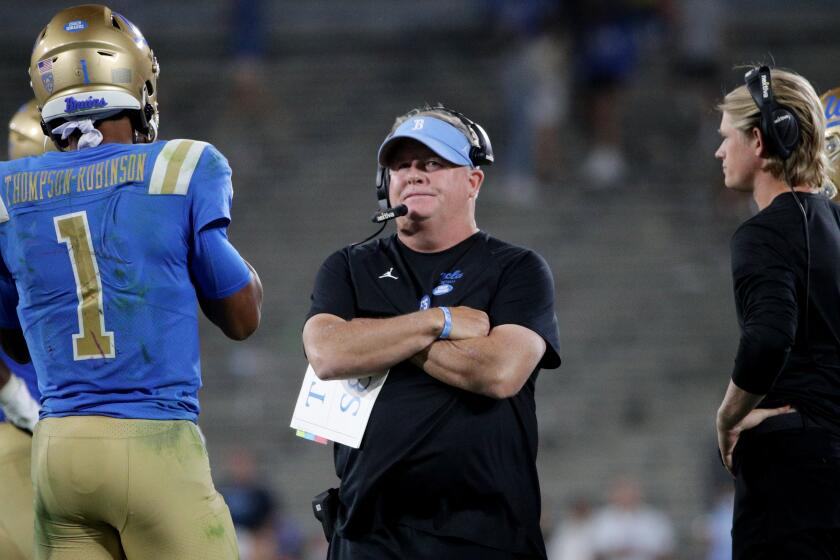 UCLA coach Chip Kelly talks with UCLA Bruins quarterback Dorian Thompson-Robinson