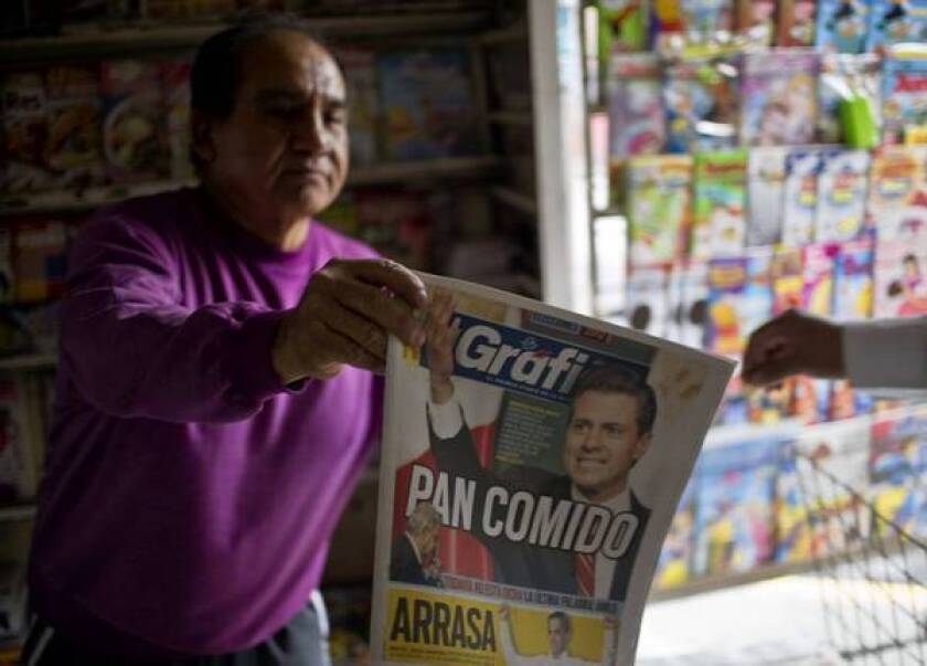 A vendor displays a newspaper featuring the Institutional Revolutionary Party's Enrique Peña Nieto, the winner of Mexico's presidential election.
