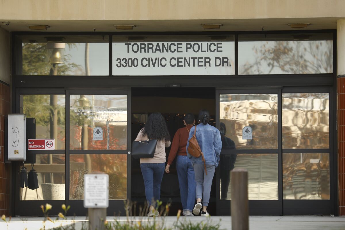 People walk into the front doors of the Torrance Police Department