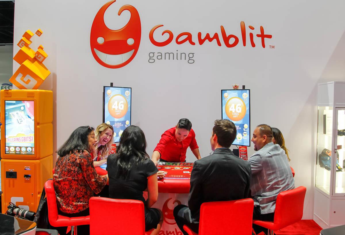 A group of people play Gamblit Poker Live at the Gamblit booth during the Indian Gaming Convention on Thursday in San Diego, California. (Eduardo Contreras/Union-Tribune)