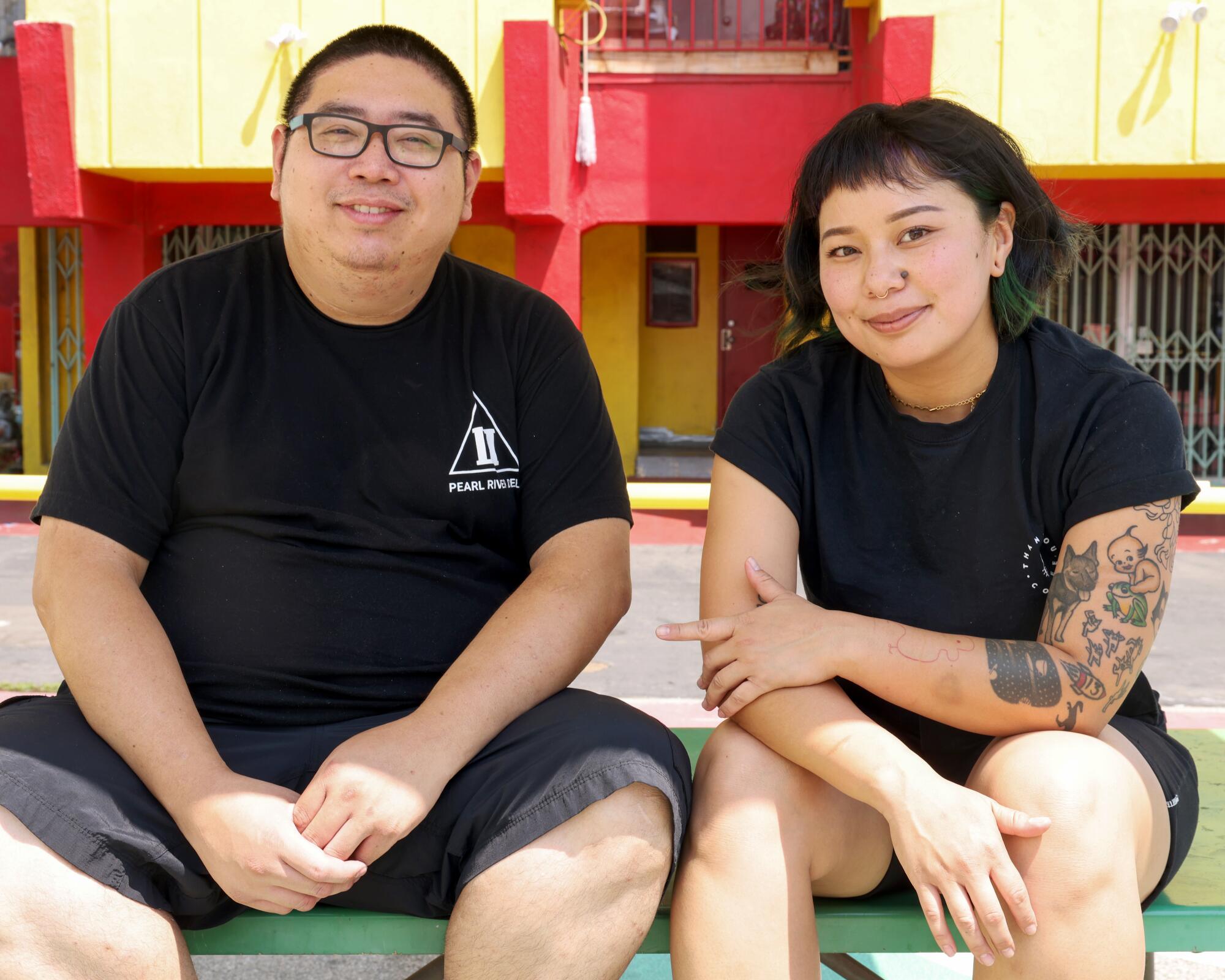 A man and a woman sit on a bench.