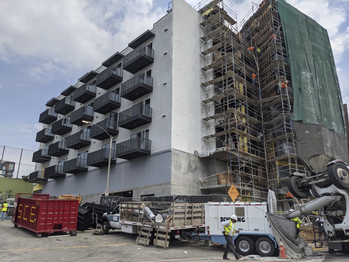 Construction workers finish the exterior of an apartment building in downtown Los Angeles. 