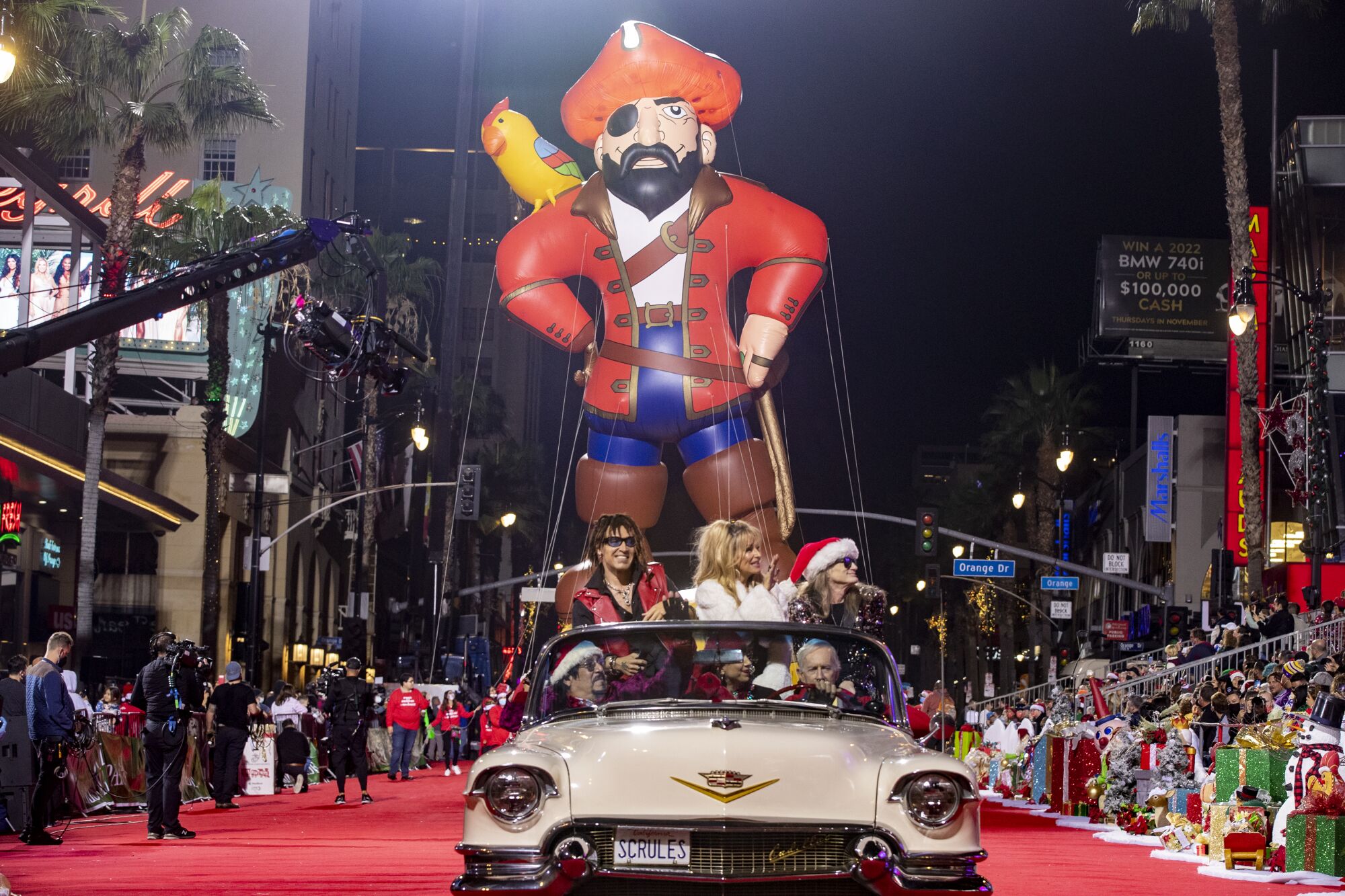 A four-story pirate parade float makes its way down a red-carpeted Hollywood Boulevard