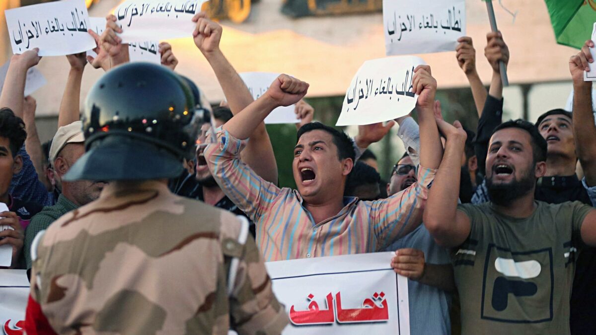 Iraqi protesters chant Sunday in Baghdad's Tahrir Square.
