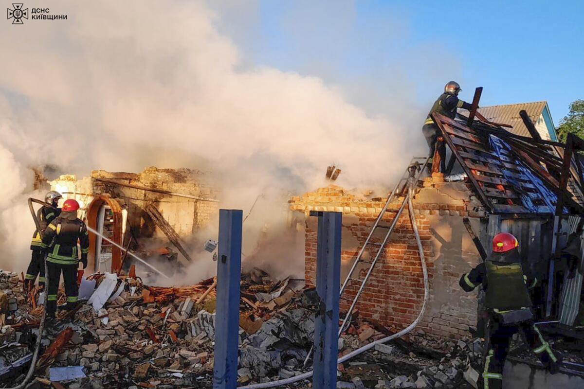 Ukrainian rescuers work at a damaged building