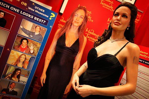 A wax figure of Angelina Jolie, right, at Madame Tussauds is posed next to a photograph of Jolie as she is seen in wax at the Hollywood Wax Museum. The display is part of a marketing effort by Madame Tussauds. See full story