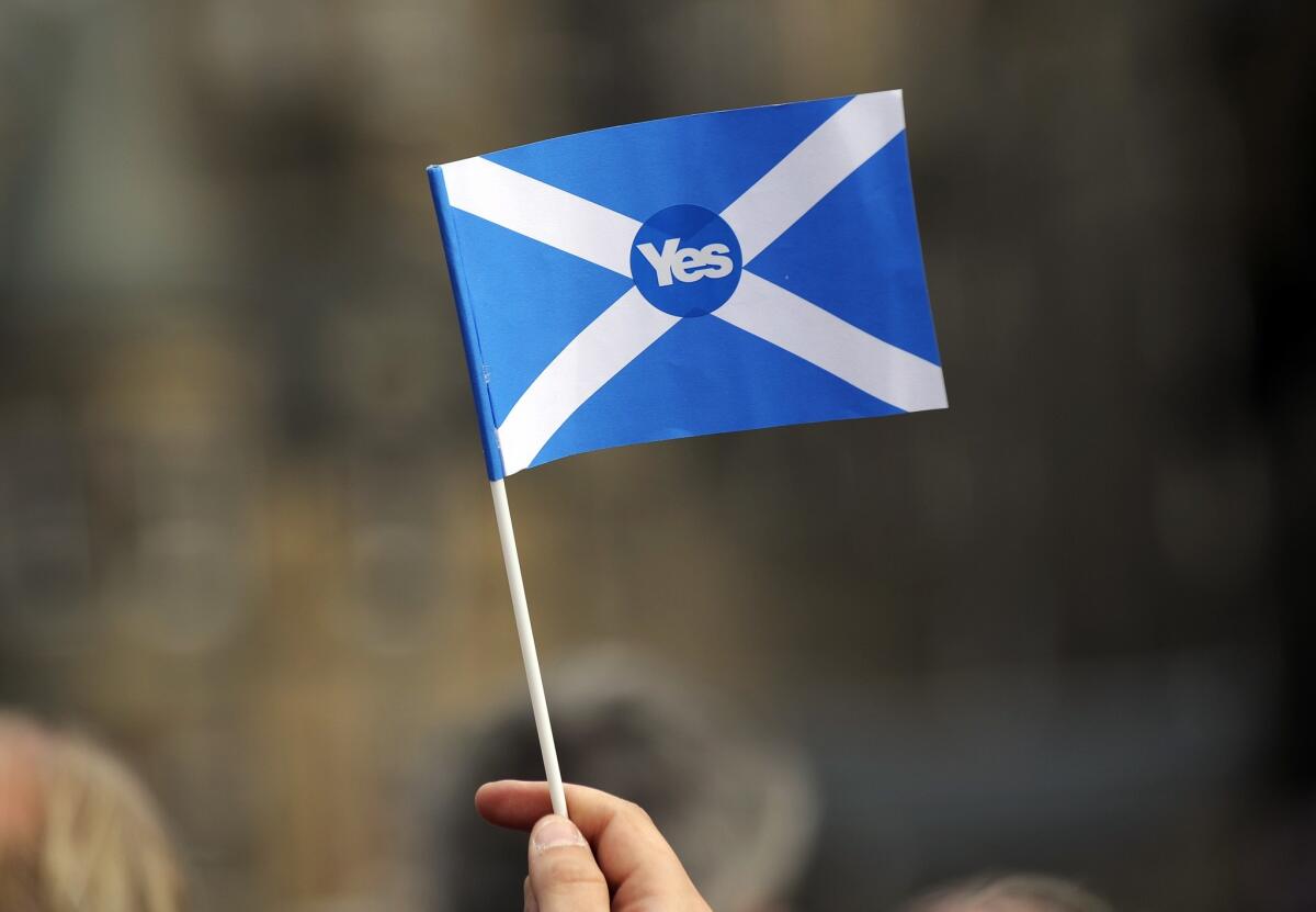 A pro-independence supporter holds a "Yes" flag as Scottish MP Jim Murphy addresses pro-union "Better Together" campaign supporters in Edinburgh, Scotland, on Monday.