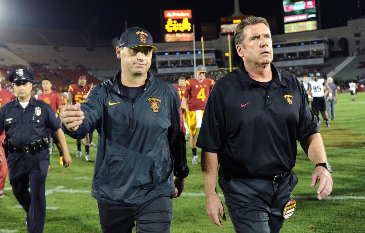 USC Coach Steve Sarkisian, left, walks off the field after losing to Washington, 17-12, at the Coliseum on Oct. 8.