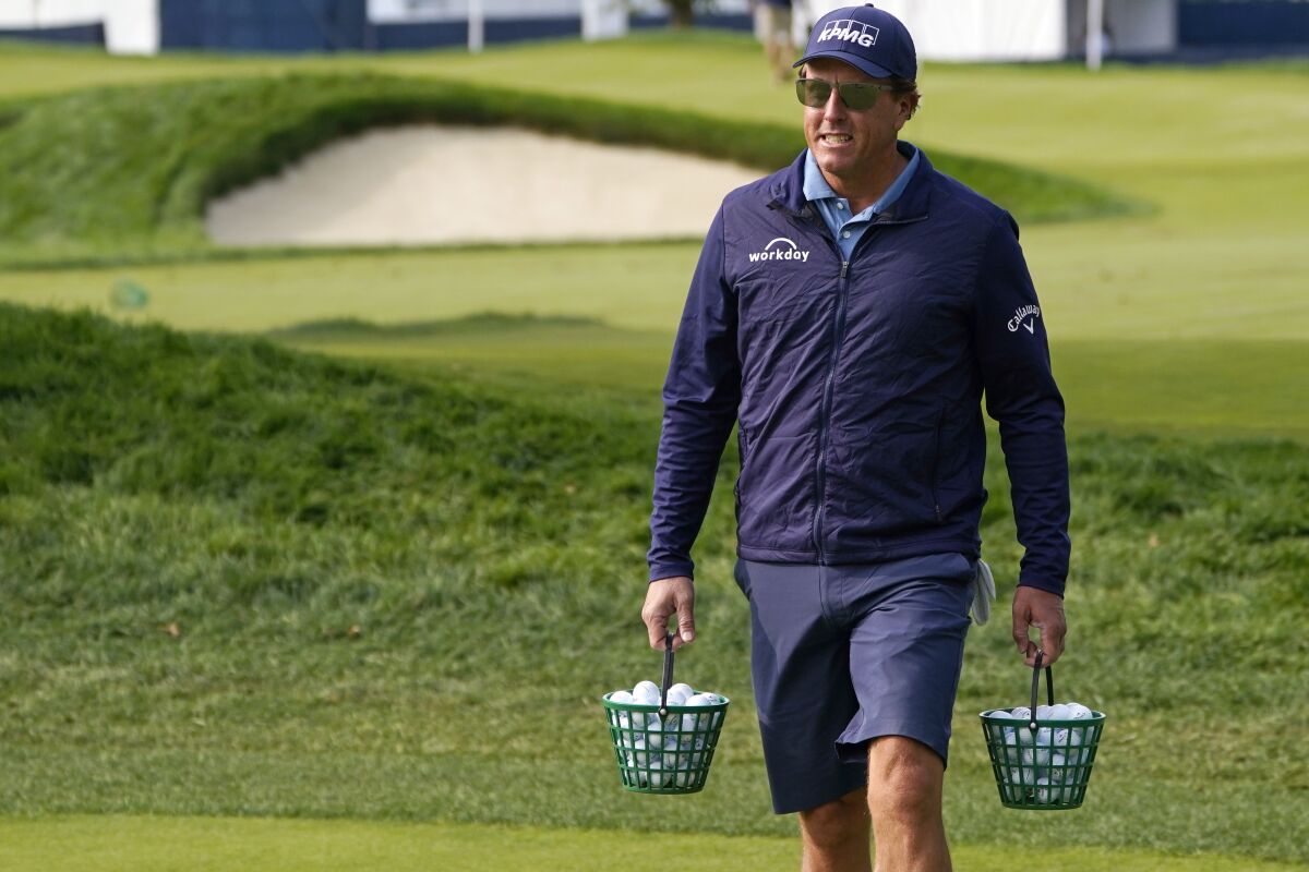 Phil Mickelson carries two buckets of balls as he heads to the range prior to a practice round before the U.S. Open Championship golf tournament, Tuesday, Sept. 15, 2020, at the Winged Foot Golf Club in Mamaroneck, N.Y. (AP Photo/Charles Krupa)