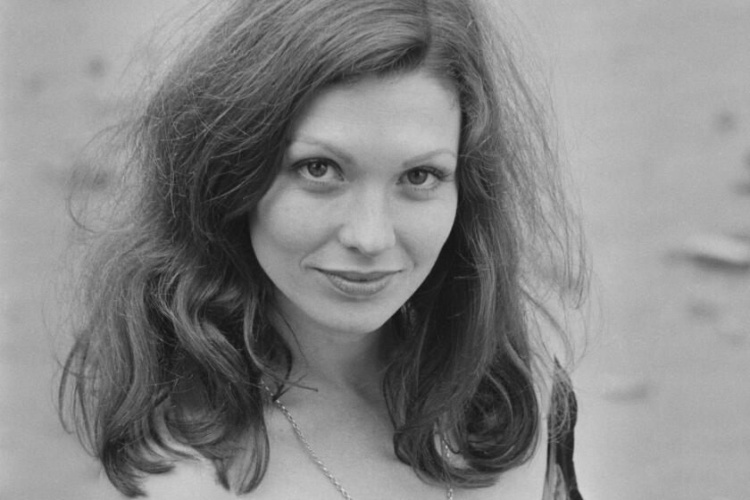 A black and white photo of a woman with long hair looking up 