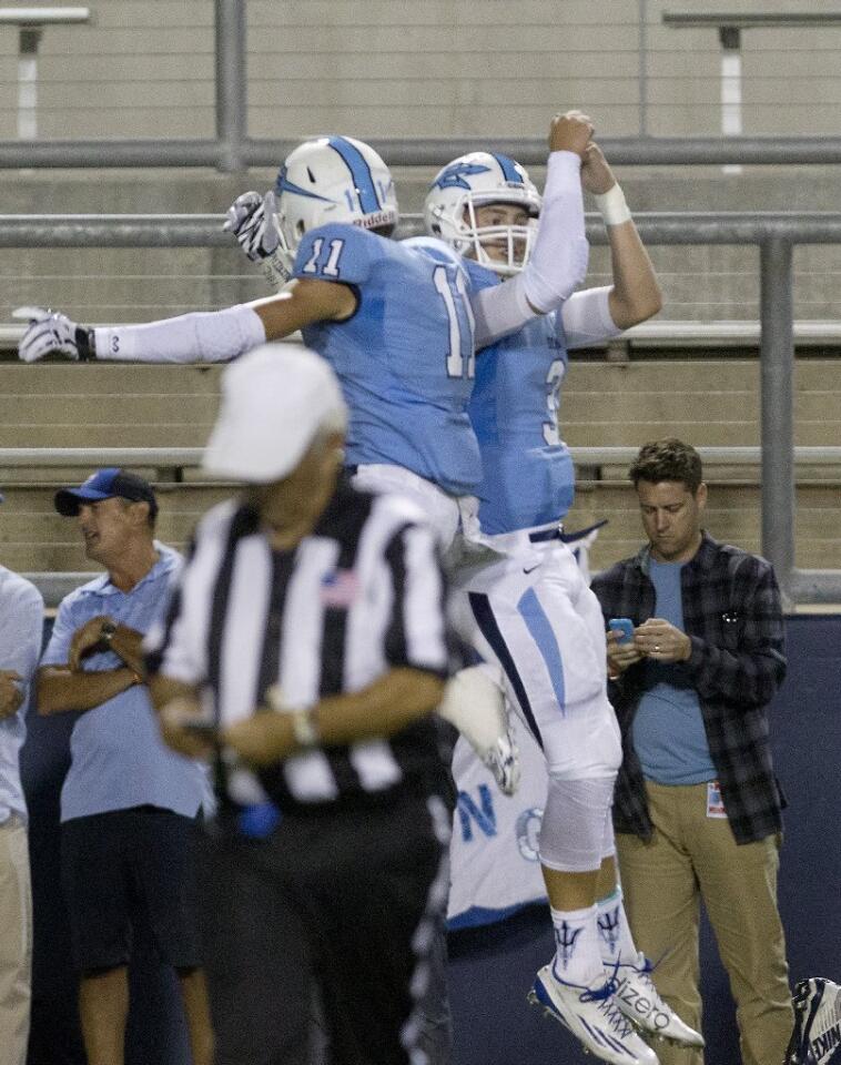 Corona del Mar High's Dylan Tucker (11) and quarterback Chase Garbers celebrate after Garbers scored a touchdown during the first half against Newport Harbor.