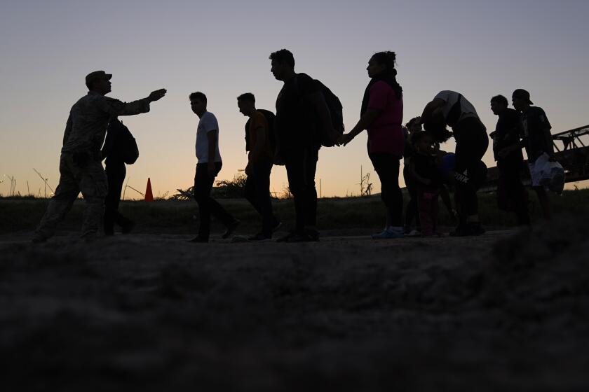 FILE - Migrants who crossed the Rio Grande and entered the U.S. from Mexico are lined up for processing by U.S. Customs and Border Protection, Sept. 23, 2023, in Eagle Pass, Texas. U.S. authorities say border arrests during July have plummeted to a new low for Joe Biden’s presidency, raising prospects that a temporary ban on asylum may be lifted soon. The Border Patrol is expected to arrest migrants about 57,000 times during the month, down about 30% from June and the lowest tally since September 2020, when COVID-19 slowed movement across many borders. (AP Photo/Eric Gay, File)