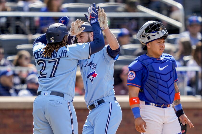 Toronto Blue Jays' Brandon Belt, center, celebrates with Vladimir Guerrero Jr. (27) after hitting a two-run home run off New York Mets relief pitcher Dominic Leone to take the lead in the seventh inning of a baseball game, Sunday, June 4, 2023, in New York. (AP Photo/John Minchillo)