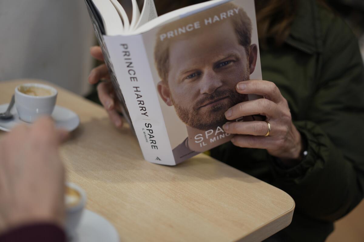 Una persona lee una copia del nuevo libro "Spare" del príncipe Enrique en una librería de Roma