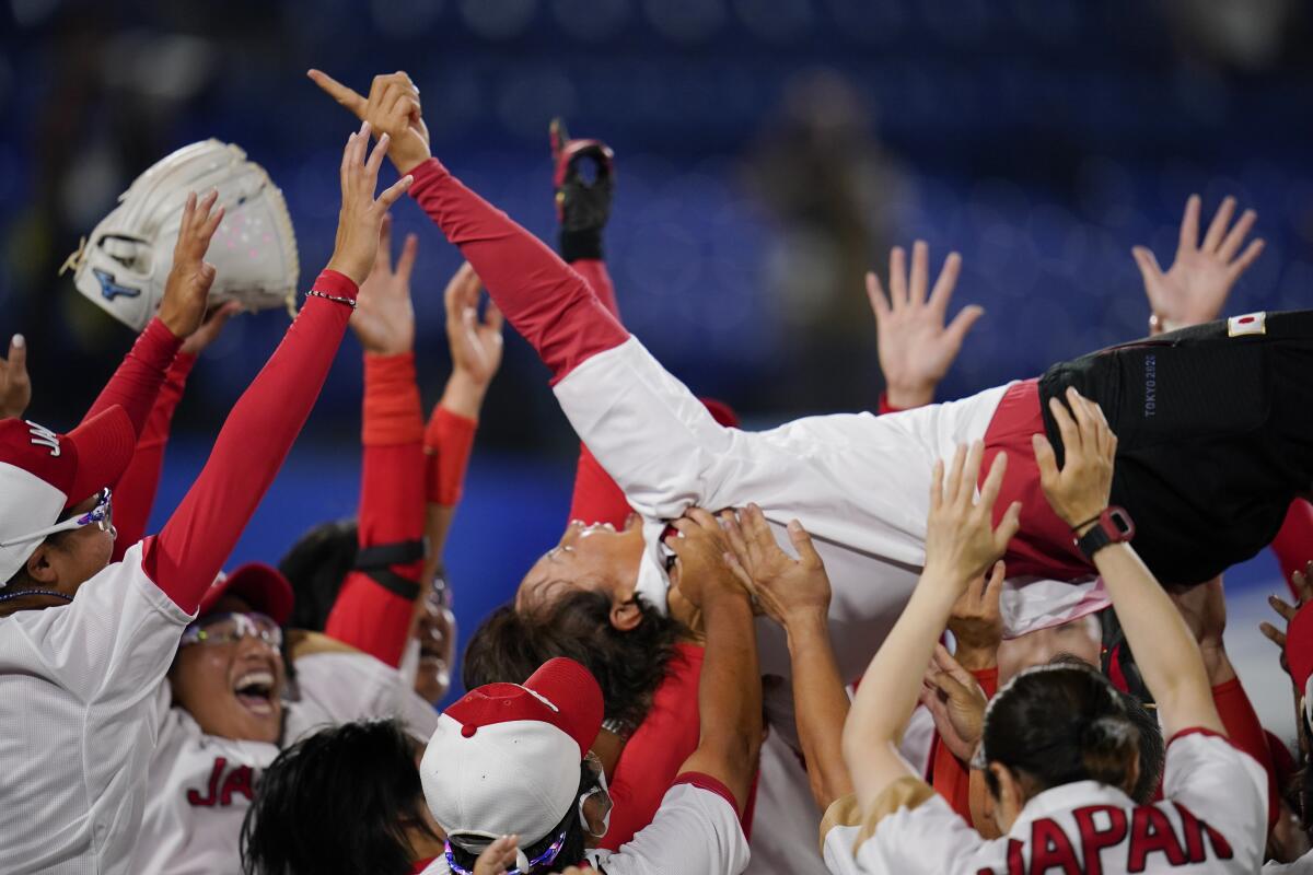 Members of Japan's softball team celebrate after defeating the U.S. 2-0 in the gold medal game. 