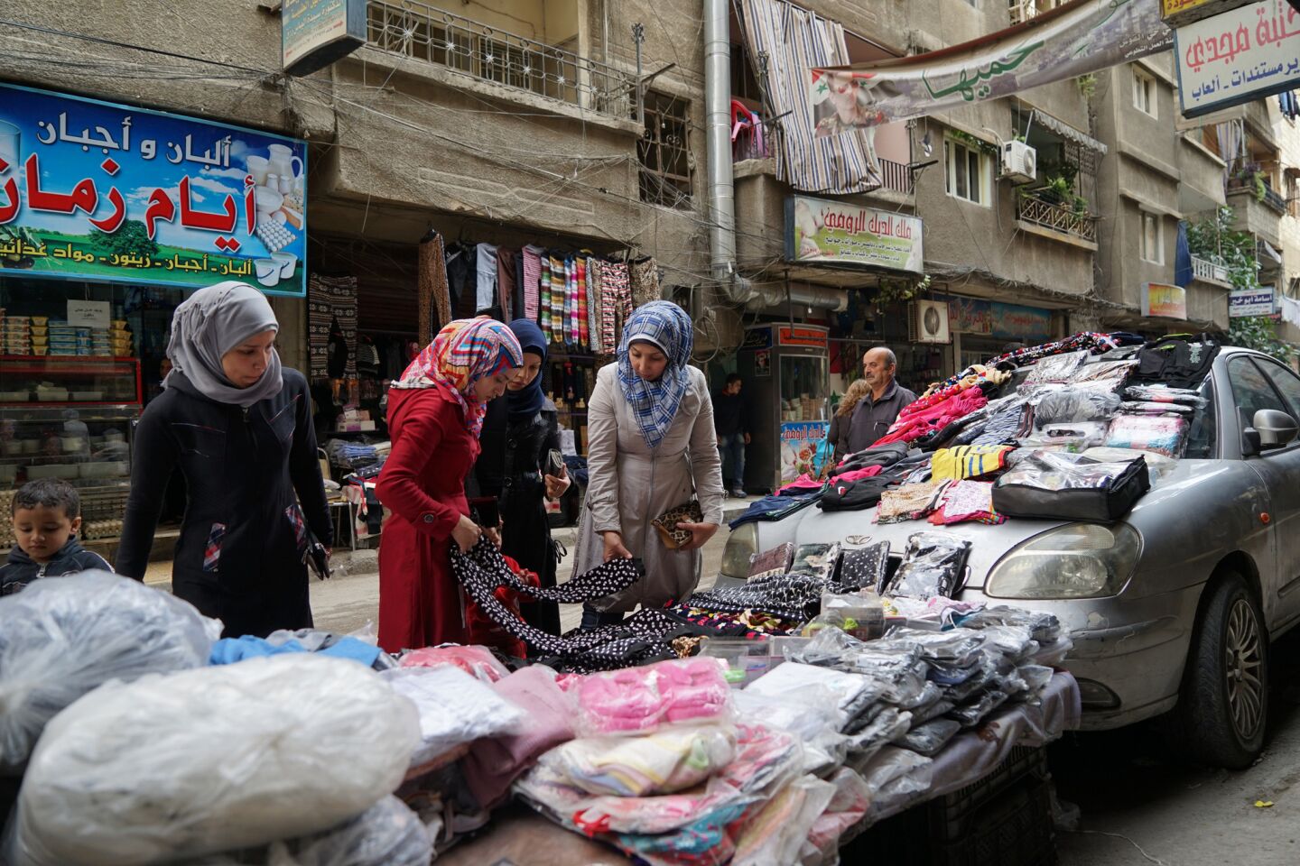 Women shop in Jaramana, a densely populated suburb of Damascus. The neighborhood, to which many people displaced by the war have moved, is under tight government control.