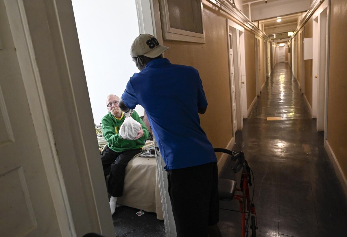 Serving Seniors driver Samond Hayes delivers a meal to Sean Smyth in San Diego.