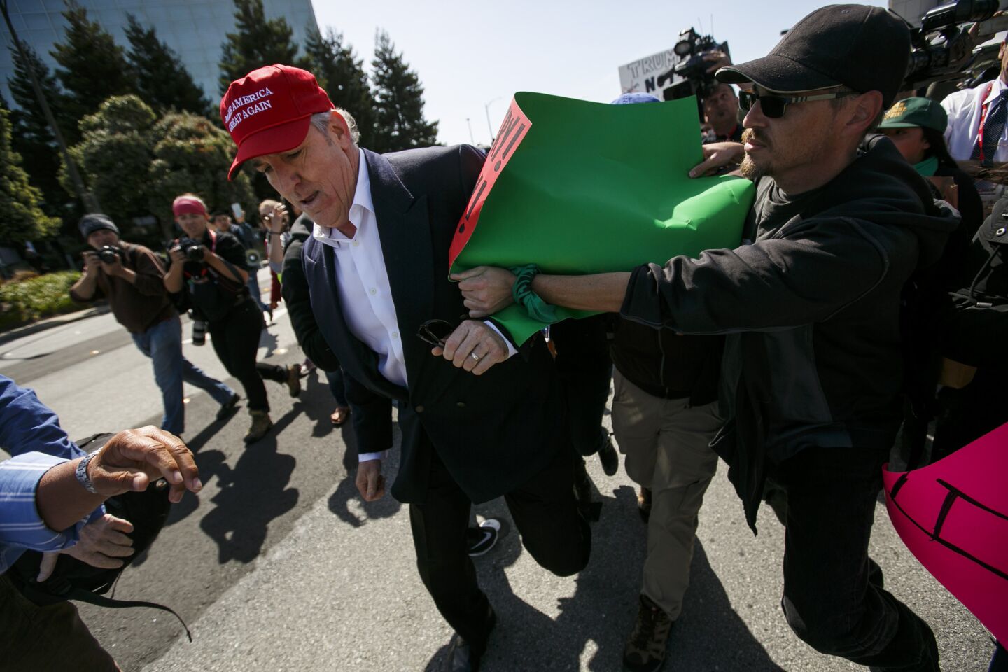 A Donald Trump supporter is surrounded by Trump protesters as he makes his way toward the California Republican Convention, in Burlingame on April 29, 2016/