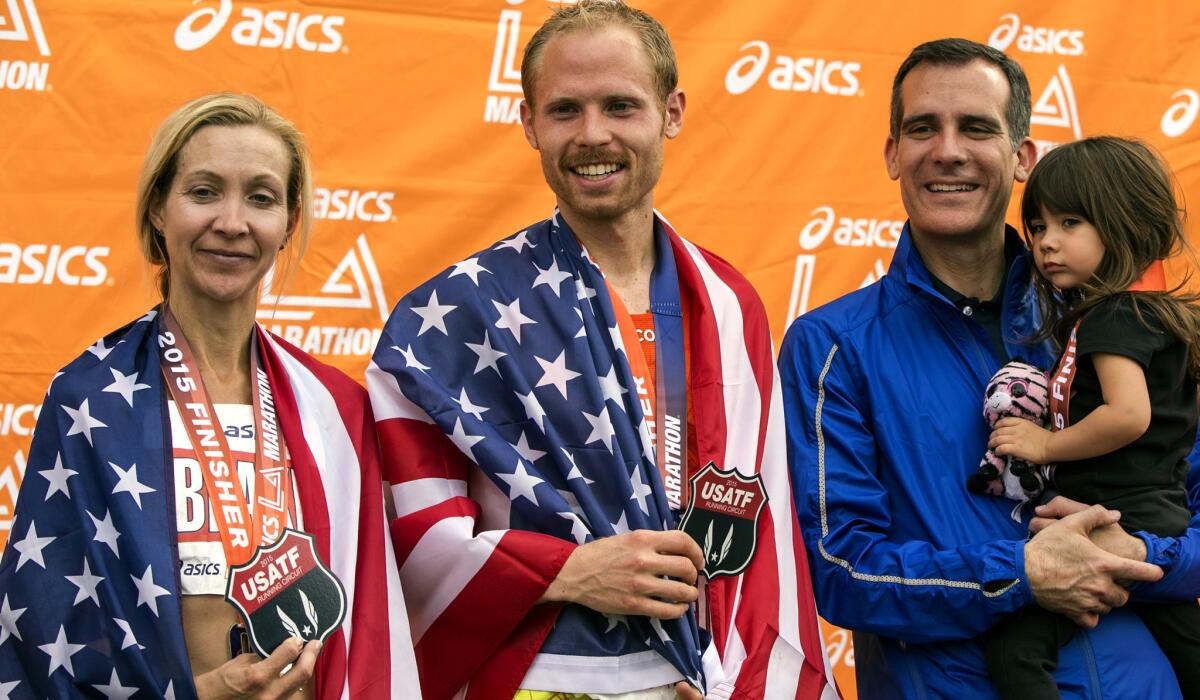 American runners Blake Russell, left, and Jared Ward pose for a photo with Mayor Eric Garcetti and his daughter Maya after finishing third in the women's and men's L.A. Marathon on Sunday.
