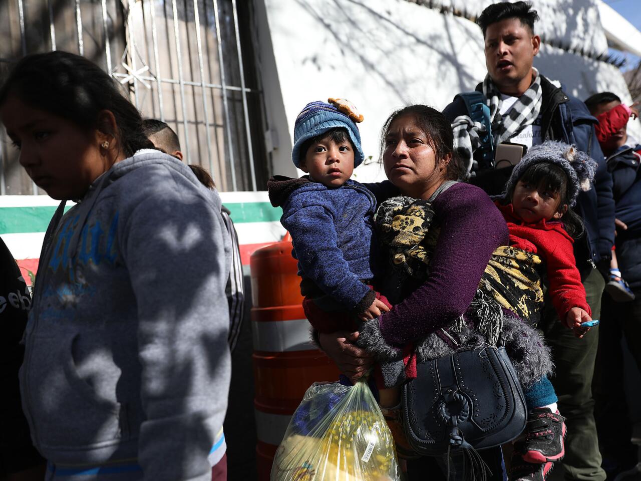 Migrants from Honduras, Mexico, Cuba and Guatemala wait to turn themselves in to U.S. Customs and Border Protection agents in Ciudad Juarez, Mexico. U.S. border officials finalized plans to require asylum seekers to remain in Mexico while their cases are considered in the United States.