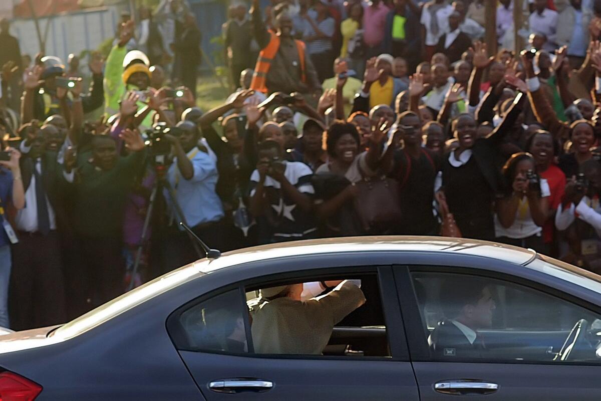 Pope Francis, riding in a Honda sedan, waves at crowds as he passes through the streets of Nairobi, Kenya, on Nov. 25.