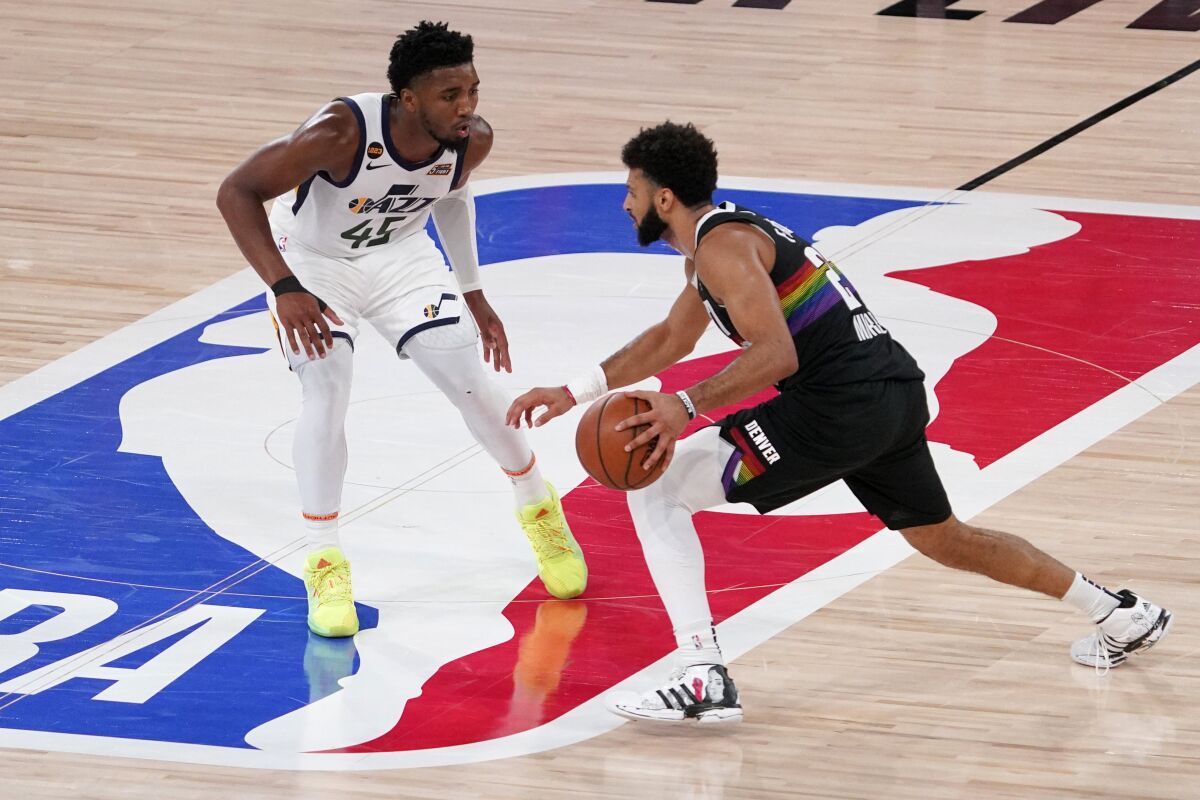 Utah Jazz's Donovan Mitchell (45) defends as Denver Nuggets' Jamal Murray (27) advances the ball down court during the second half an NBA first round playoff basketball game, Tuesday, Sept. 1,2020, in Lake Buena Vista, Fla. (AP Photo/Mark J. Terrill)