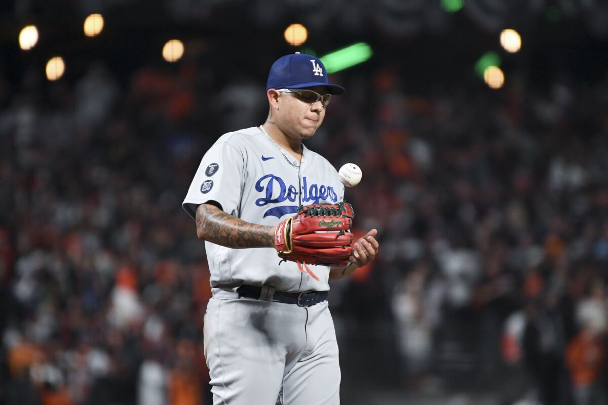 Dodgers starting pitcher Julio Urías tosses the ball after allowing a solo home run.