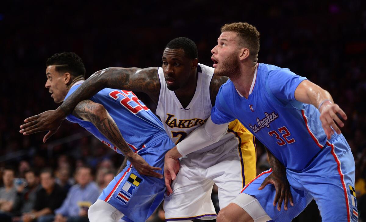 Clippers forwards Matt Barnes, left, and Blake Griffin screen out Lakers forward Tarik Black in the first half.