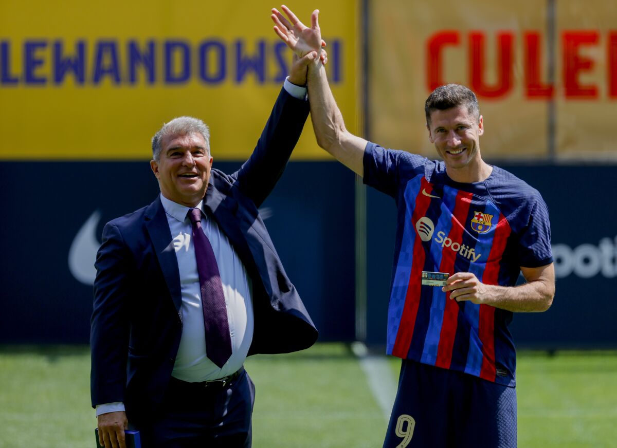 Polish forward Robert Lewandowski, right, and FC Barcelona President Joan Laporta react, during the official presentation after signing for FC Barcelona, in Barcelona, Spain, Friday, Aug. 5, 2022. (AP Photo/Joan Monfort)