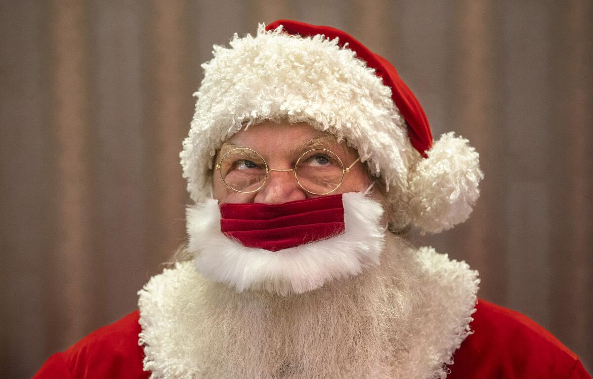 Jeffrey Fast wears a protective mask while dressed as Santa Claus in Canoga Park. 