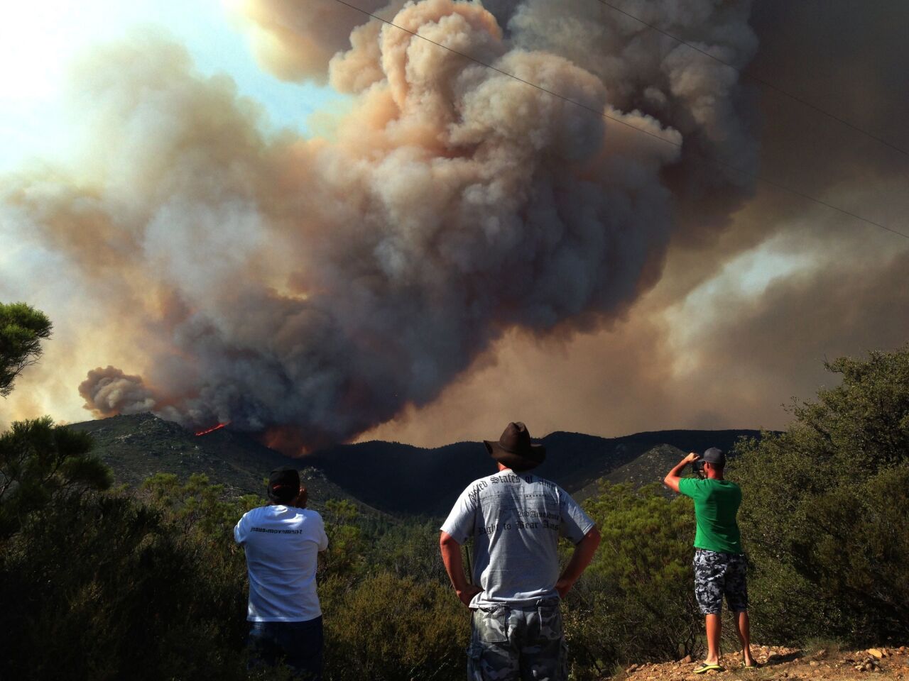 The Mountain fire looms in the background of Morris Ranch Road off Highway 74 in Garner Valley on July 17. Authorities ordered more evacutations in the area.