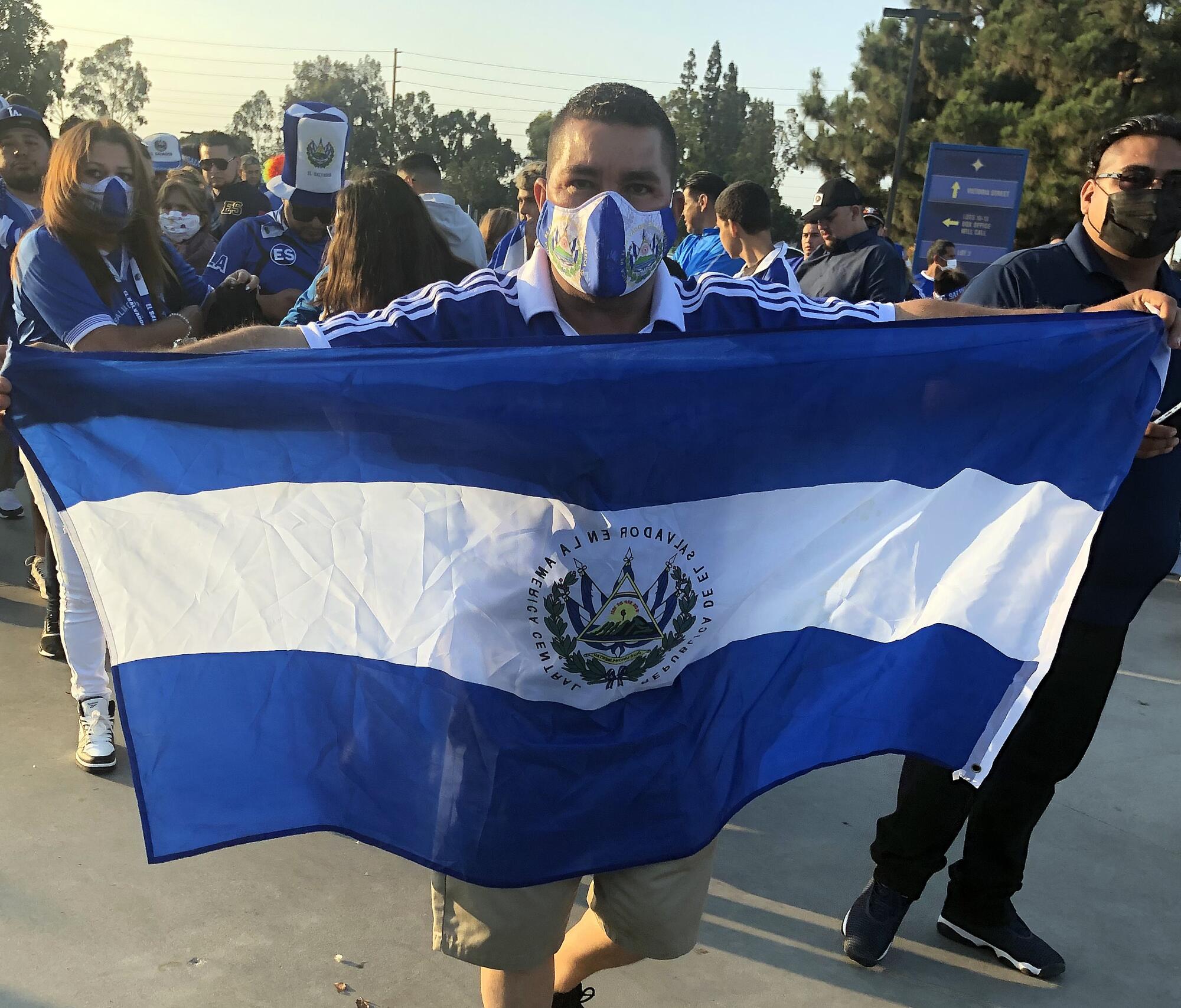A Salvadoran fan holds a flag during a rally before the Salvadoran-Costa Rica soccer match 