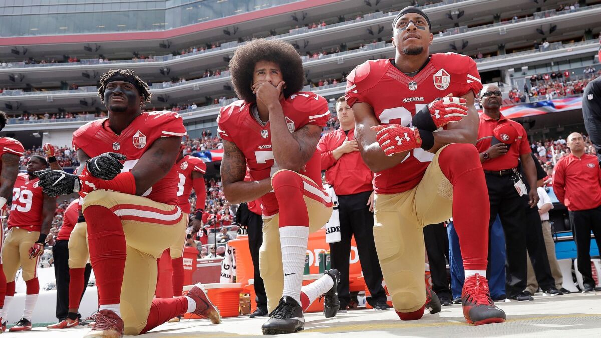 San Francisco 49ers quarterback Colin Kaepernick, center, and teammates kneel during the national anthem in Santa Clara, Calif. on Oct. 2, 2016.