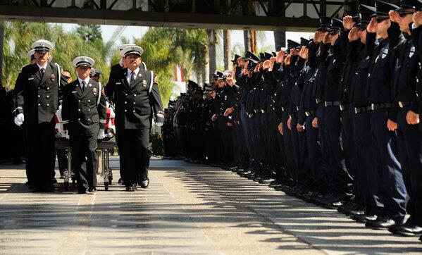 Colleagues stand at attention as the casket of fallen firefighter Kevin Woyjeck, 21, is brought in for a service at the Christ Cathedral campus in Garden Grove on Tuesday. Woyjeck was killed, along with 18 other firefighters, in a blaze in Yarnell, Ariz., on June 30.