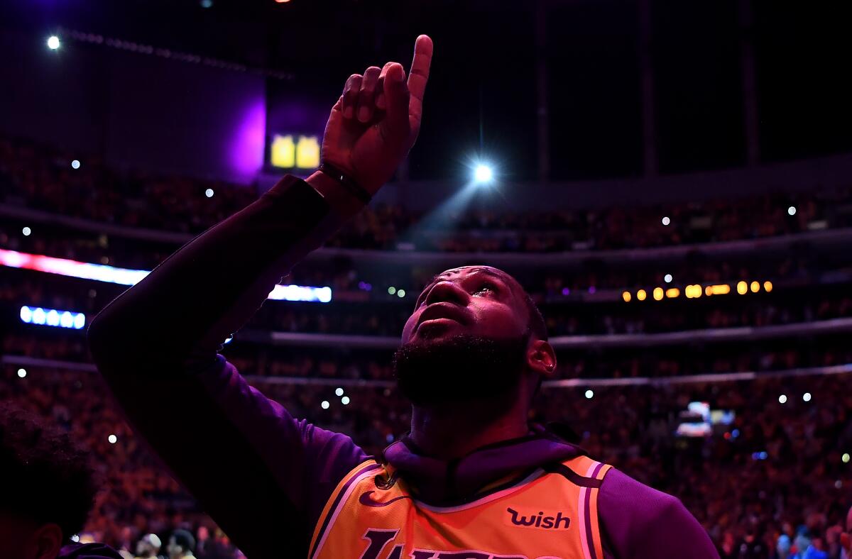 LeBron James points to the sky during a moment to honor Kobe Bryant in the Lakers' first game after the legend's death.