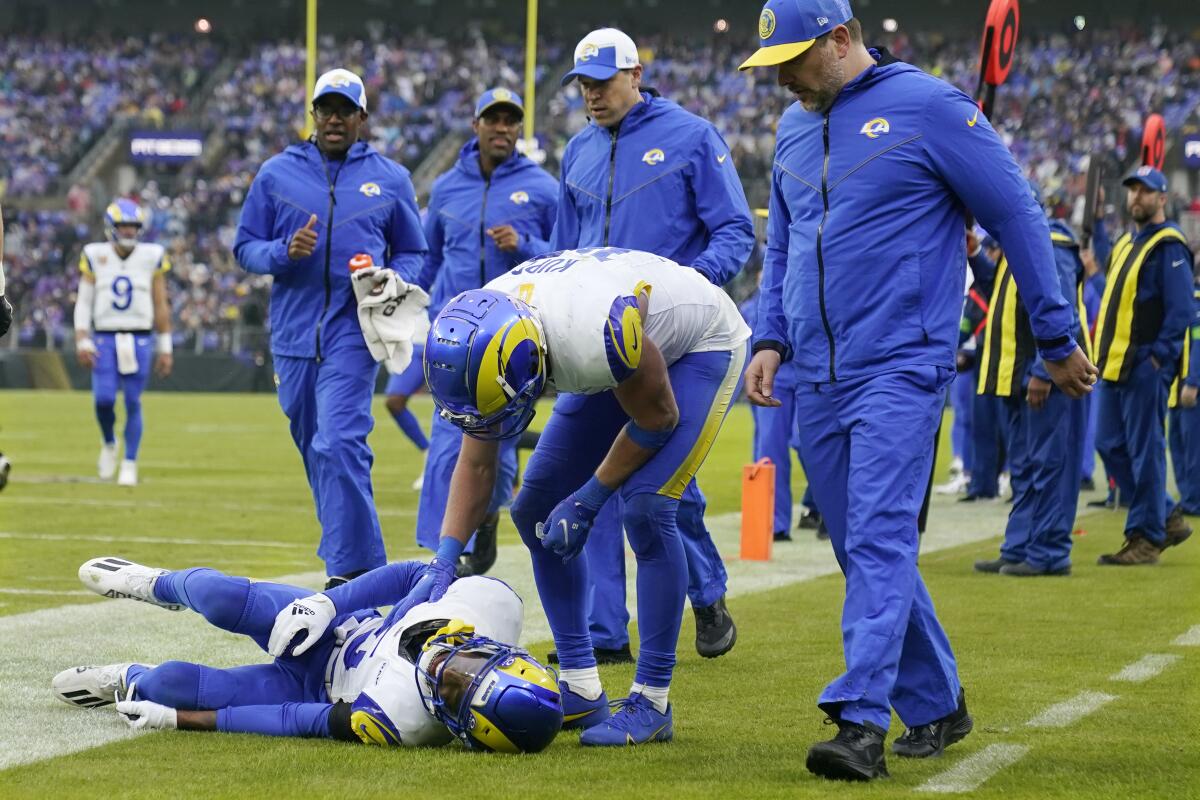 Rams receiver Tutu Atwell is on the ground after suffering a concussion.  Cooper Kupp checks on his teammate.