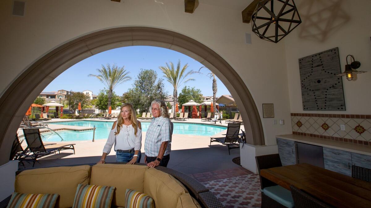 Pam Watkins and husband Craig stand near one of the seniors-only pools at Rancho Mission Viejo, a multi-generational community in South Orange County.