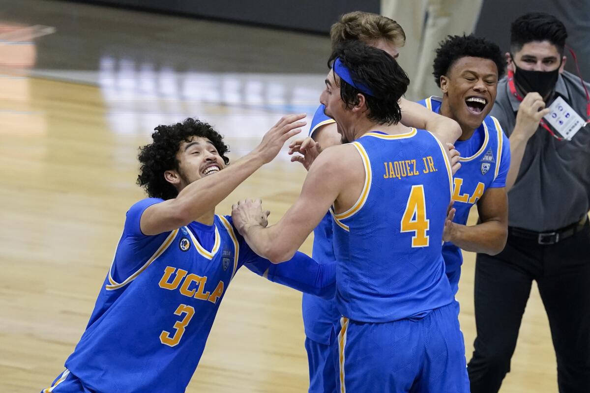UCLA's Johnny Juzang, left, and Jaime Jaquez Jr. celebrate after the Bruins' Elite 8 win over Michigan in Indianapolis.