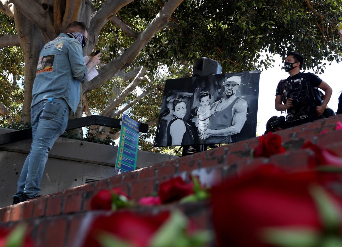 Roses line a set of steps as a large poster of George Floyd is on display during the Juneteenth event at Sasscer Park.
