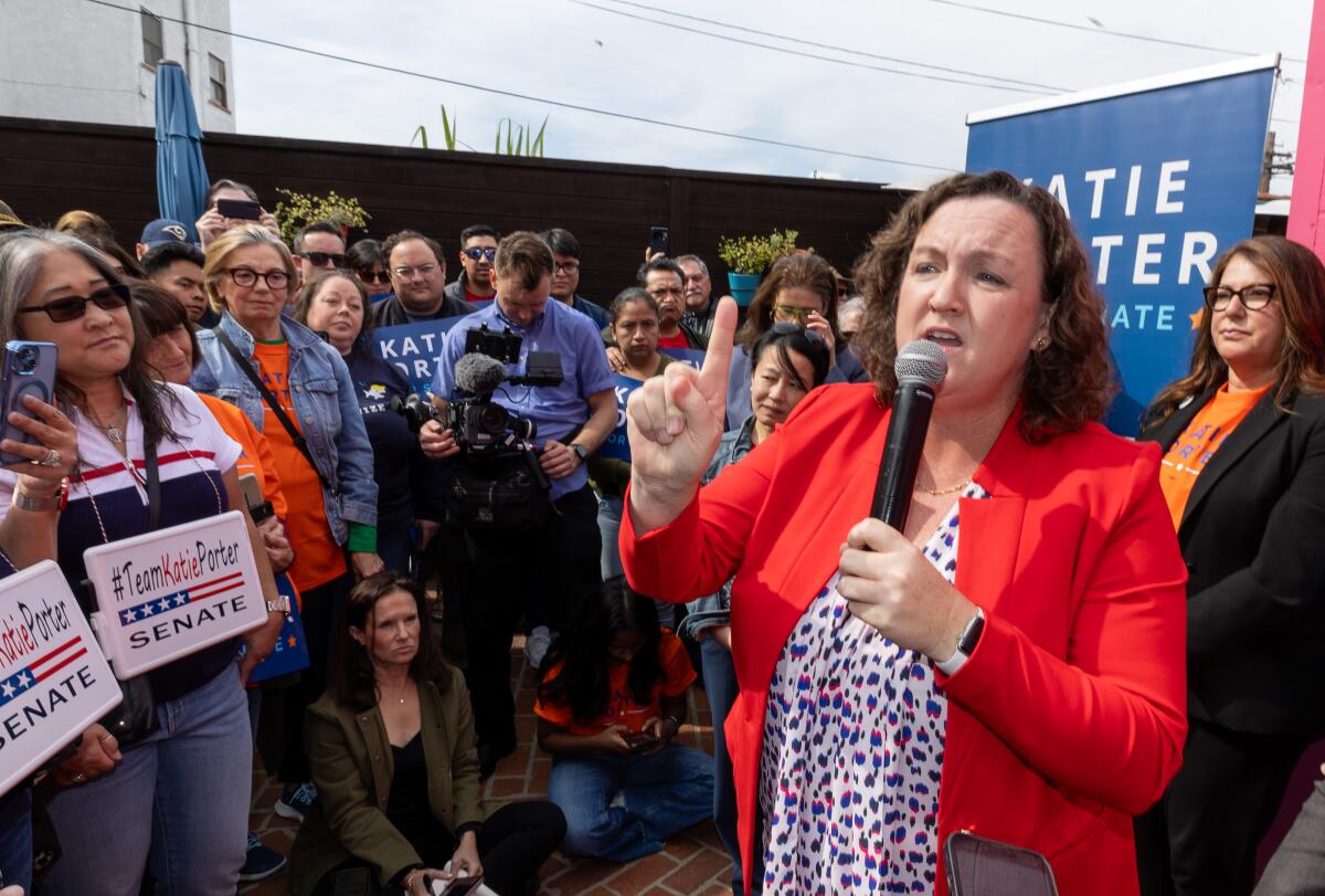 Rep. Katie Porter in front of several people at a campaign event outside.