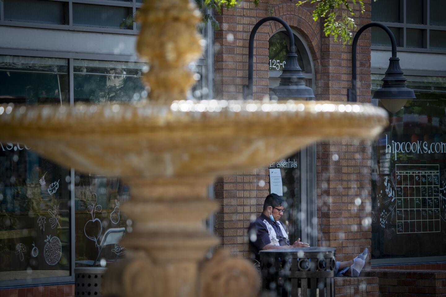 Ray Gonzalez takes a break from the heat near a water fountain after having lunch in the arts district in downtown Santa Ana.
