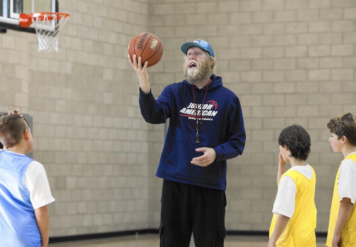 Brian Beerbower, known as 'Mr. Dude' and director of the new Costa Mesa-based Junior American Basketball program, conducts a youth basketball clinic at TeWinkle Middle School on Thursday.
