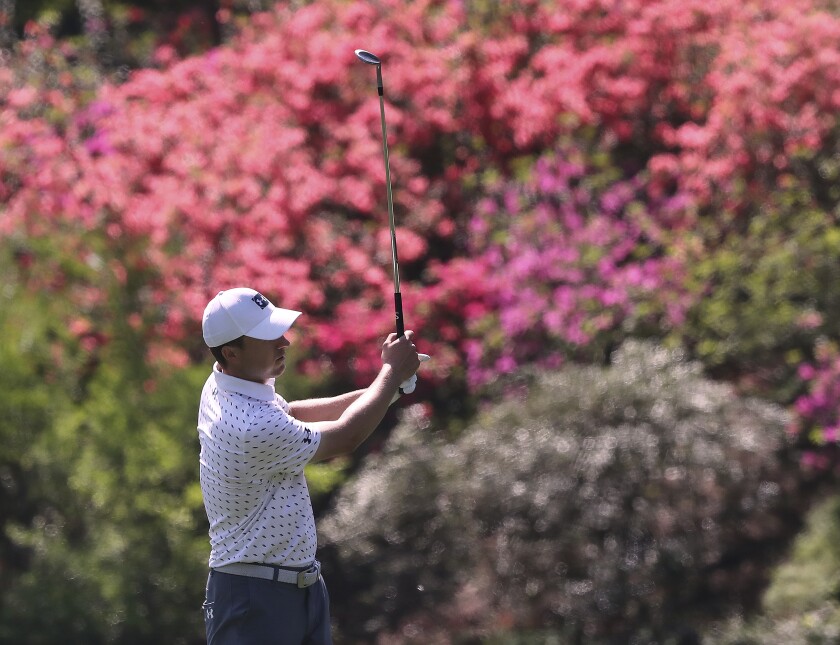 The azaleas are beginning to pop as Jordan Spieth chips to the 13th green during his practice round for the Masters at Augusta National Golf Club on Tuesday, April 6, 2021, in Augusta, Ga. (Curtis Compton/Atlanta Journal-Constitution via AP)