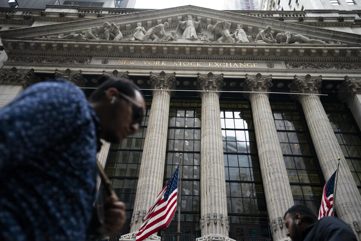 Pedestrians pass the New York Stock Exchange, Monday, Oct. 4, 2021, in New York. U.S. stocks are opening mixed on Friday, Oct. 8, after a disappointing jobs report thudded onto Wall Street and raised questions about whether the Federal Reserve will change its timeline to pare back its support for markets.(AP Photo/John Minchillo)