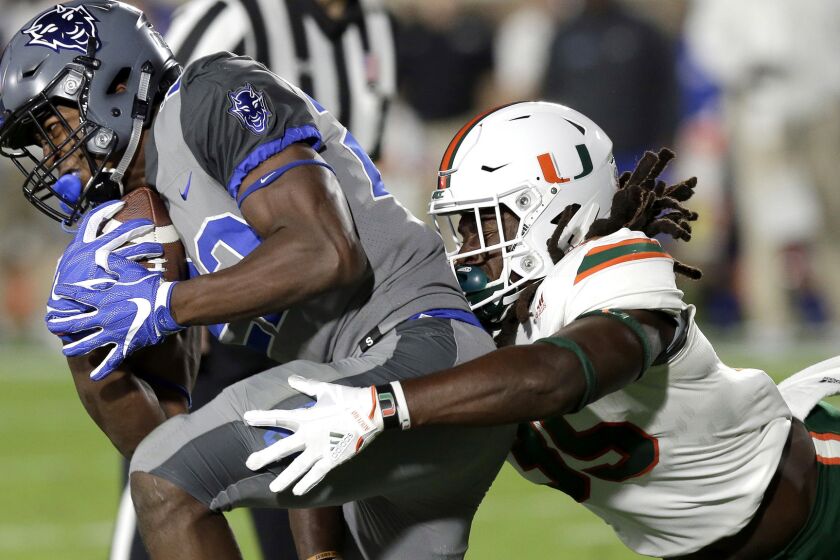 Miami's Mike Smith, right, reaches to tackle Duke's Brittain Brown during the first half of an NCAA college football game in Durham, N.C., Friday, Sept. 29, 2017. (AP Photo/Gerry Broome)