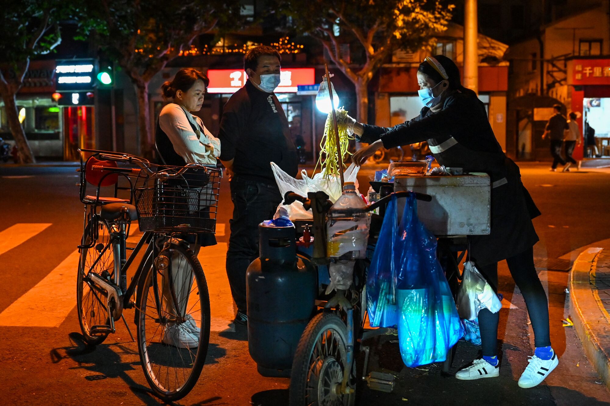 İnsanlar Şangay'daki bir sokak satıcısından erişte satın alıyor