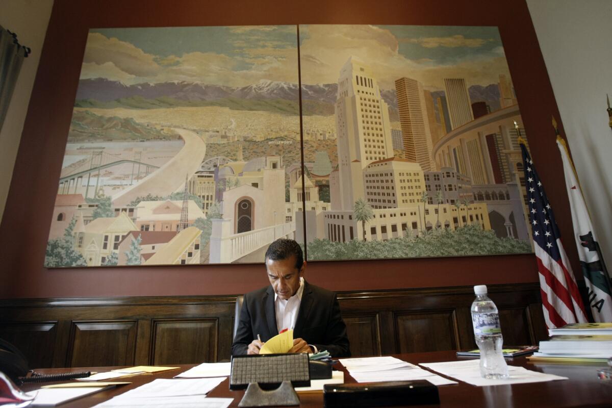 Los Angeles Mayor Antonio Villaraigosa signs papers in his office at Los Angeles City Hall in Los Angeles.