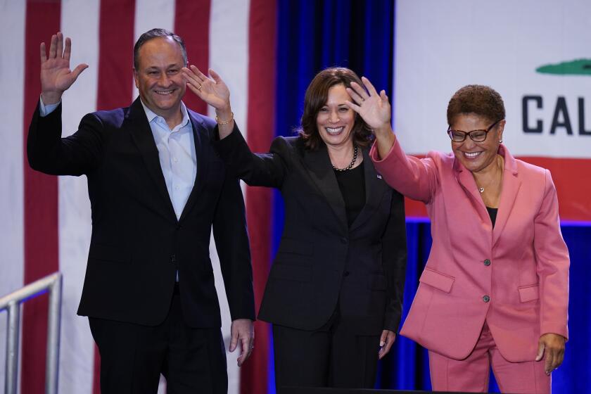 Vice President Kamala Harris, center, waves toward the crowd with husband Doug Emhoff, left, and Los Angeles mayoral candidate Rep. Karen Bass, D-Calif., after speaking at a "Get Out the Vote" rally in Los Angeles, Monday, Nov. 7, 2022. (AP Photo/Jae C. Hong)