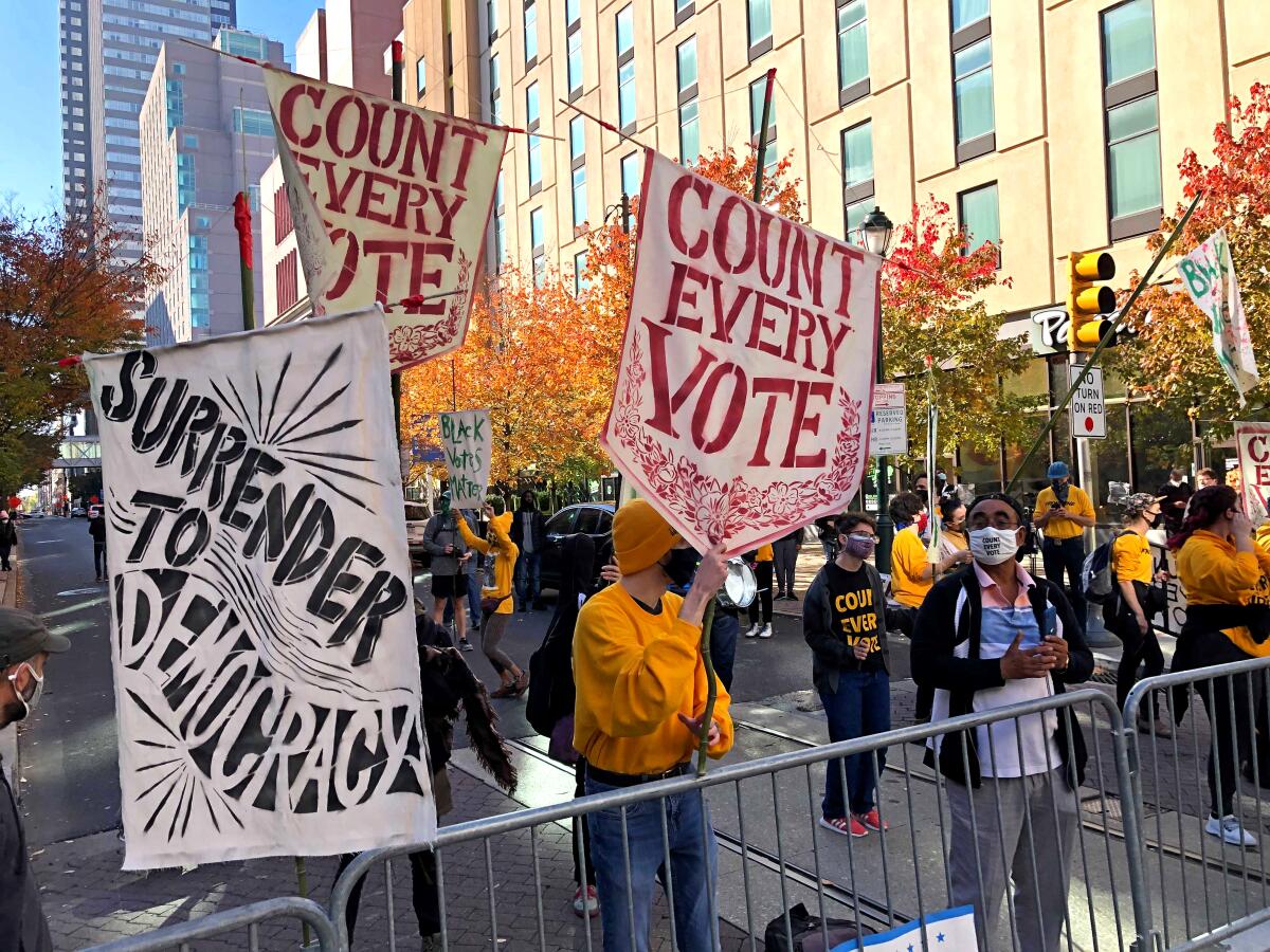 Protestors in Philadelphia on Nov. 5 hold banners denouncing efforts to limit vote counting after the 2020 election.